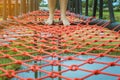 Young woman tried to walk on the bridge floor tied with a red rope to cross the swamp in the fields.