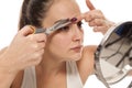 Woman trimming her eyebrows Royalty Free Stock Photo