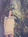 Young woman in tropical climate palm tree surrounding her