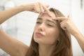 Young woman troubled checking wrinkles on her forehead Royalty Free Stock Photo