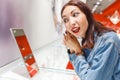 Young woman trying on earrings and looking at the mirror in jewelry store, shopping concept Royalty Free Stock Photo