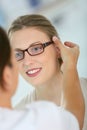 Young woman trying on eyeglasses