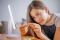 Young woman trying to apply contact lenses in front of mirror. Young girl trying on new contact lenses. Close up of girl trying on Royalty Free Stock Photo