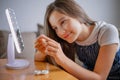 Young woman trying to apply contact lenses in front of mirror. Young girl trying on new contact lenses. Close up of girl trying on Royalty Free Stock Photo