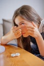 Young woman trying to apply contact lenses in front of mirror. Young girl trying on new contact lenses. Close up of girl trying on Royalty Free Stock Photo