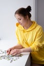 Young Woman trying to match pieces of a Jigsaw Puzzle Game. Playing board game. Royalty Free Stock Photo