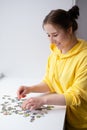 Young Woman trying to match pieces of a Jigsaw Puzzle Game. Playing board game. Royalty Free Stock Photo