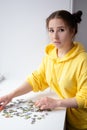 Young Woman trying to match pieces of a Jigsaw Puzzle Game. Playing board game. Royalty Free Stock Photo