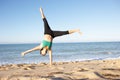 Young Woman Turning Cartwheel On Beach Royalty Free Stock Photo