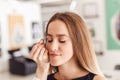 Young woman tweezing her eyebrows in beauty saloon. Royalty Free Stock Photo