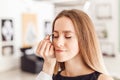 Young woman tweezing her eyebrows in beauty saloon. Royalty Free Stock Photo