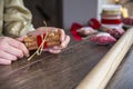 Young woman tying ribbon on gift box on wooden background Royalty Free Stock Photo