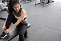 young woman tying shoelace in fitness center. female athlete prepare for training in gym. sporty girl lacing her shoes before Royalty Free Stock Photo