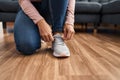 Young woman tying shoelace at home Royalty Free Stock Photo