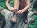 Young woman tyoing her boots in forest Royalty Free Stock Photo