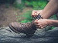 Young woman tyoing her boots in forest Royalty Free Stock Photo