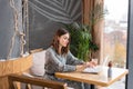 Young woman Typing on the keyboard, chatting, maintains a blog. Freelancer work on netbook in modern coworking Royalty Free Stock Photo