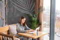 Young woman Typing on the keyboard, chatting, maintains a blog. Freelancer work on netbook in modern coworking Royalty Free Stock Photo