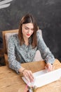 Young woman Typing on the keyboard, chatting, maintains a blog. Freelancer work on netbook in modern coworking Royalty Free Stock Photo