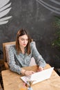 Young woman Typing on the keyboard, chatting, maintains a blog. Freelancer work on netbook in modern coworking Royalty Free Stock Photo