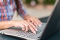 Young woman typing on a laptop keyboard working outdoors Royalty Free Stock Photo