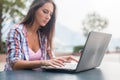 Young woman typing on a laptop studying or working in the park Royalty Free Stock Photo