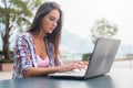 Young woman typing on a laptop studying or working in the park Royalty Free Stock Photo
