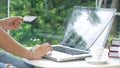 The young woman typing and transaction credit card on laptop