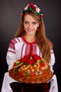 Young woman in ukrainian clothes and round loaf