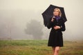 Young fashion woman with umbrella walking in a fog outdoor Royalty Free Stock Photo