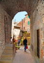 Young woman under arch on the street in old historic alley in the medieval village of Anghiari near city of Arezzo in