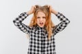 Young woman is under huge mental pressure. Portrait of freaked out shocked teen girl pulling out hair and shouting from regret,