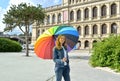 A young woman under a rainbow umbrella against the background of an exchange building. Kaliningrad Royalty Free Stock Photo