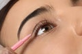 Young woman undergoing eyelash lamination, closeup. Professional service