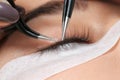 Young woman undergoing eyelashes extensions procedure