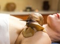 Young woman undergoing treatment with giant Achatina snails in b