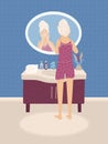 Young woman in underwear looking in the mirror in bathroom