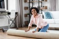 young woman unfolding carpet at home Royalty Free Stock Photo