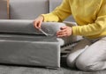 Young woman unfolding sofa into a bed in room, closeup. Modern interior Royalty Free Stock Photo