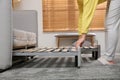 Young woman unfolding sofa into a bed in room, closeup. Modern interior Royalty Free Stock Photo