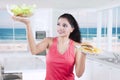 Young woman with unhealthy and healthy food Royalty Free Stock Photo