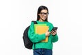 Young woman university student with backpack and books sending a sms on cell phone, isolated on white background Royalty Free Stock Photo