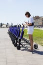 a young woman unlocks an e-scooter with her mobile phone