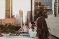 Young woman in a urban scenery at sunset taking a picture Royalty Free Stock Photo