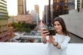 Young woman in a urban scenery taking a picture. Royalty Free Stock Photo