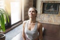 Young woman in Urdhva mukha shvanasana pose, home interior backg