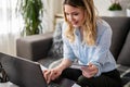 A young woman using a credit card at home to make a purchase or payment over the internet Royalty Free Stock Photo