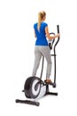 Young woman uses elliptical cross trainer.