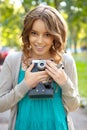 Young woman uses film photocamera.