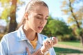 Young woman using asthma inhaler outdoors Royalty Free Stock Photo
